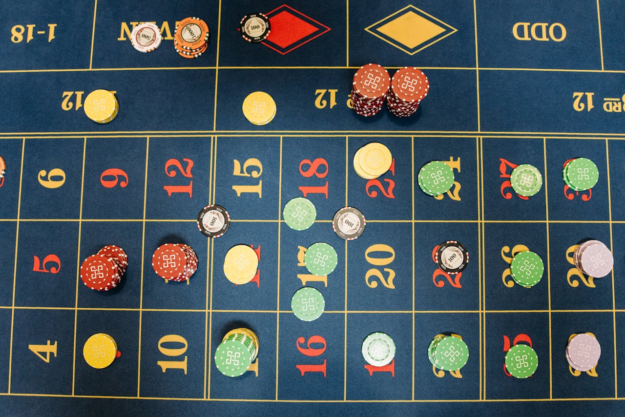 gallery-5 Aerial view of a roulette table with colorful poker chips showing a vibrant gambling scene.