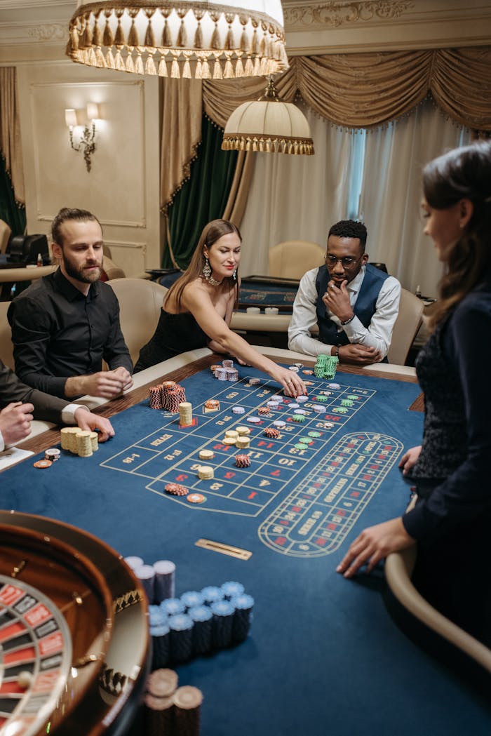 A group of adults playing a table game in a luxurious casino setting.