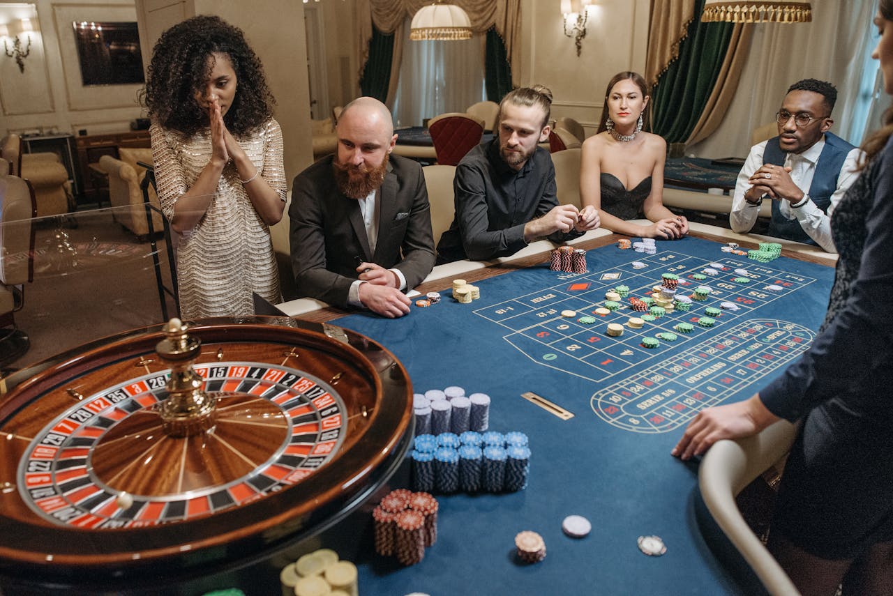 Diverse group playing roulette in a luxurious casino setting, tense and exciting atmosphere.